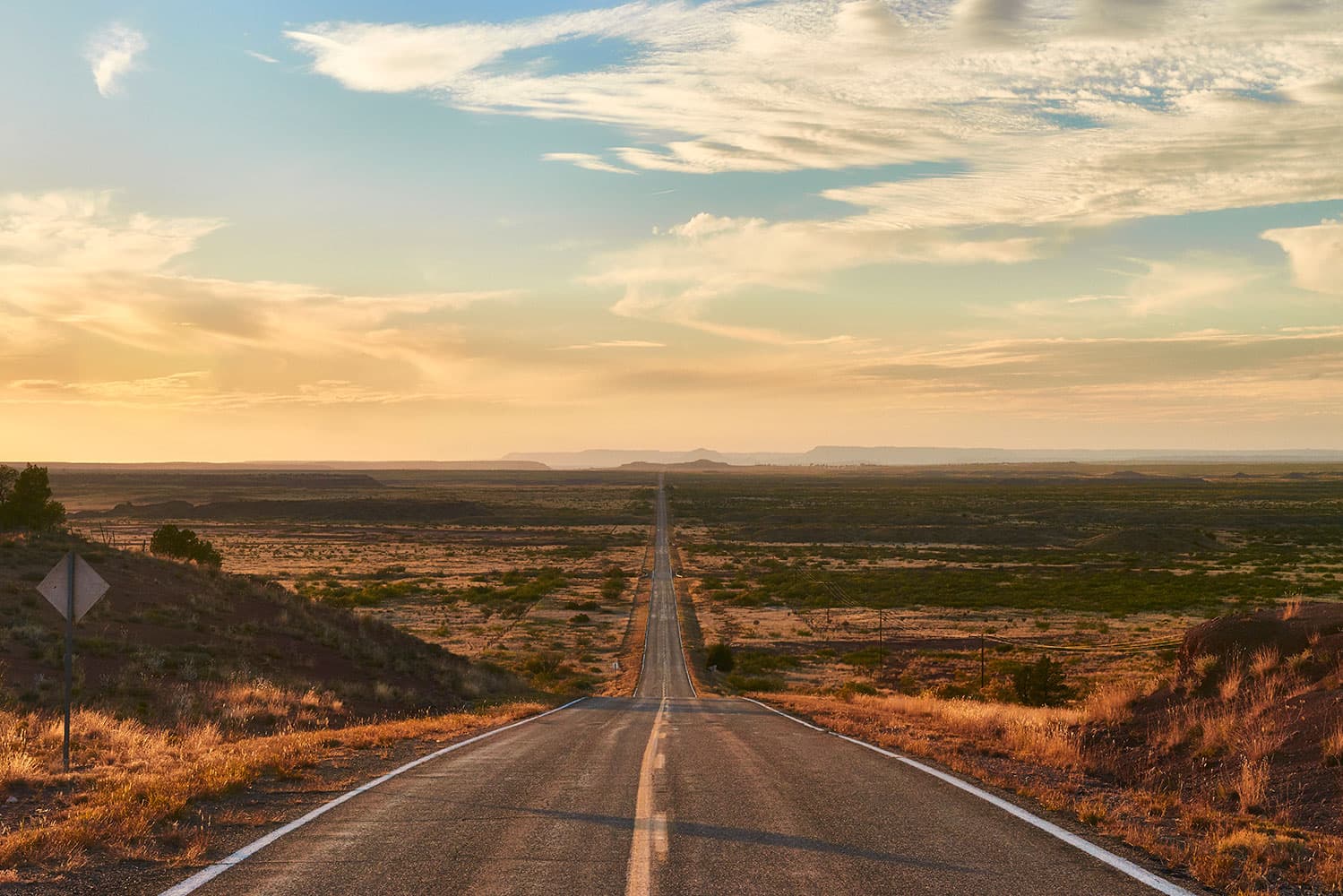 A long dessert road going into the sunset